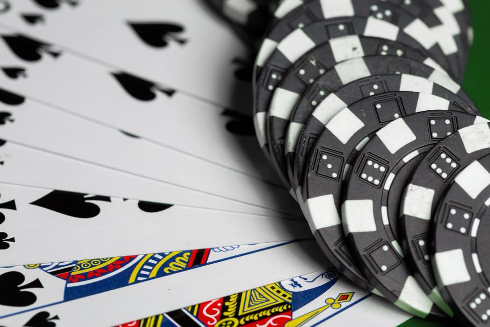 Pokerový stůl s rozdanými kartami a žetony